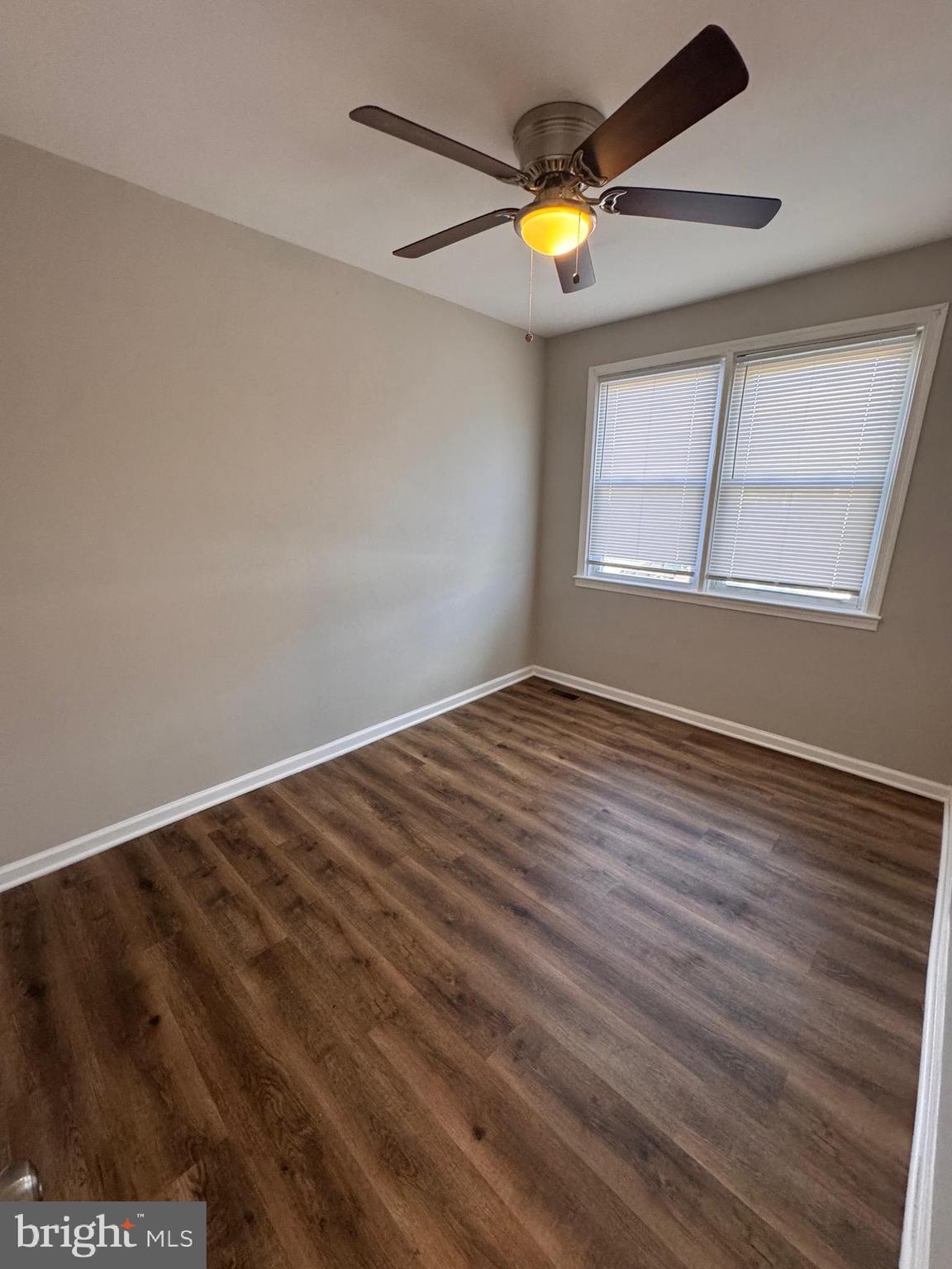 169 Hampshire Road Baltimore, MD 21221 - Photo 9 of 20 an empty room with wooden floor and windows