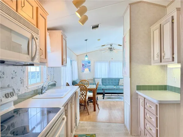 a kitchen with granite countertop a sink a stove and cabinets