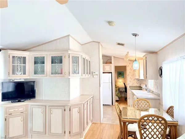 a living room with furniture a dining table and chairs with wooden floor