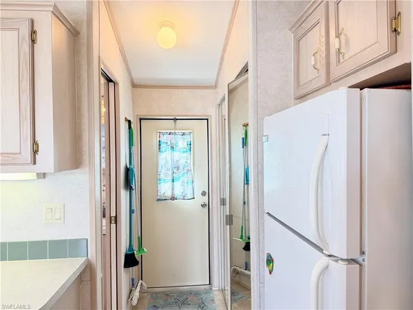a view of a hallway with a refrigerator and a window