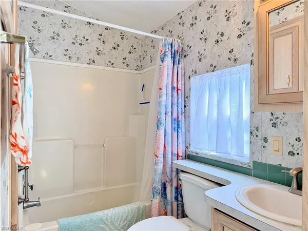 a bathroom with a toilet and a shower curtain