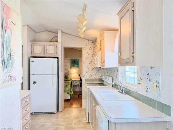 a kitchen with a sink a stove and a refrigerator