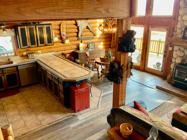 76 Highway 118 Monroe, UT 84754 - Photo 29 of 76 Kitchen featuring dishwasher, glass insert cabinets, tile countertops, a kitchen bar, and a peninsula