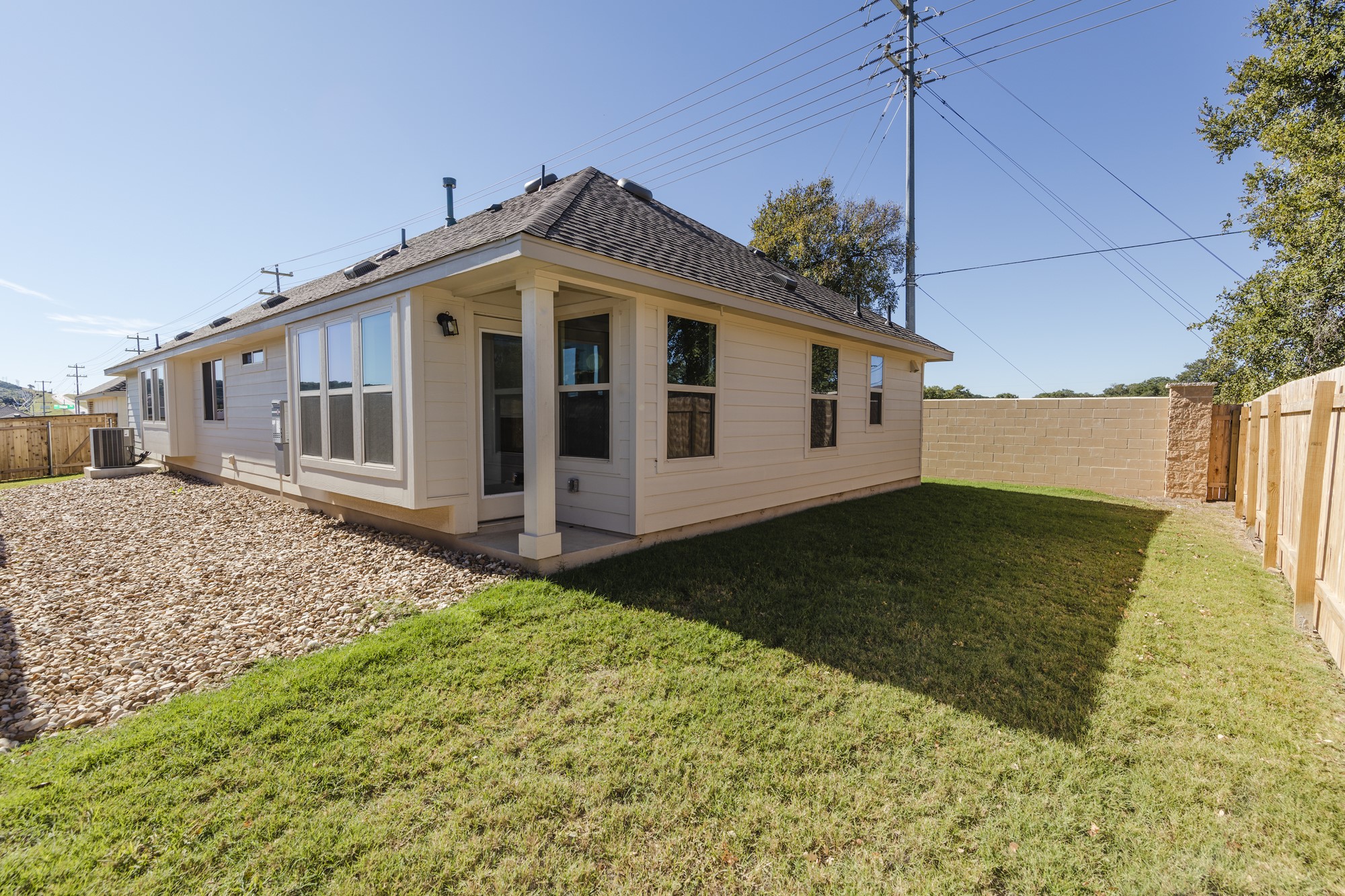 2725 Hopi Path Leander, TX 78641 - Photo 8 of 30 A well-maintained lawn and stone ground cover frame the rear of this inviting single-story residence.