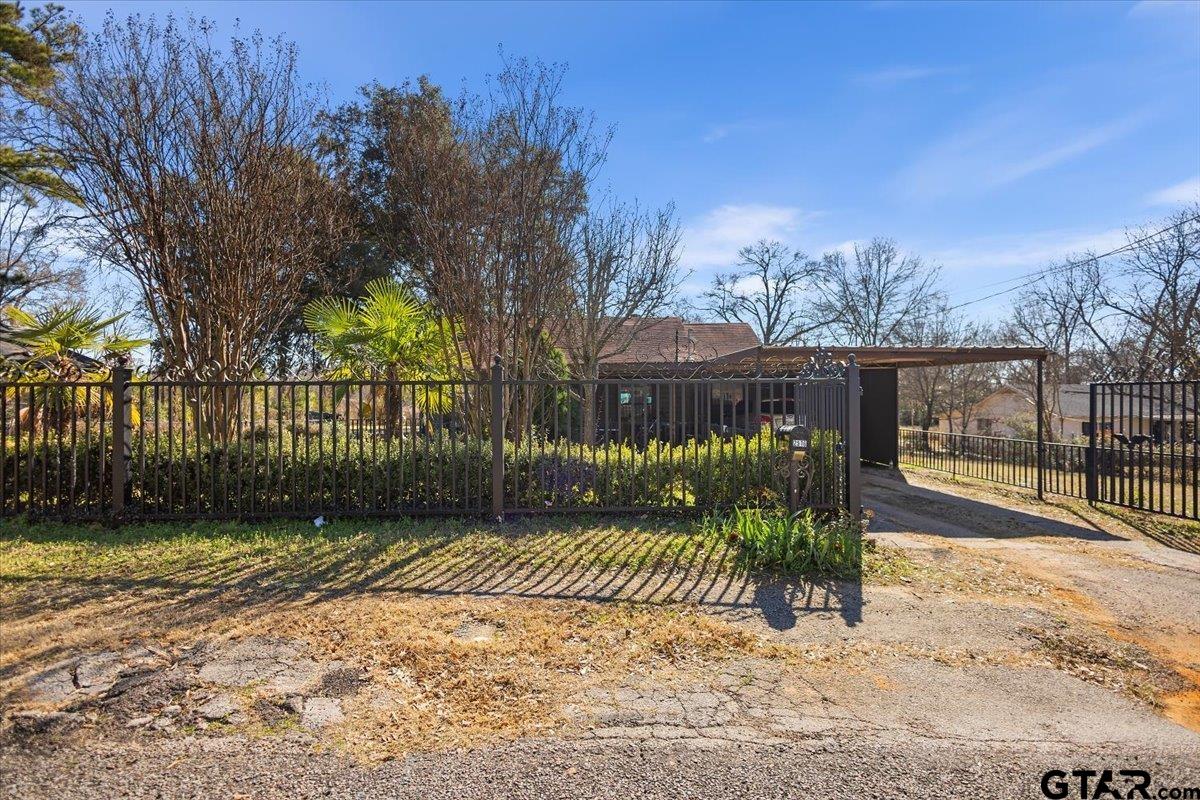 a view of a park with a large trees with wooden fence