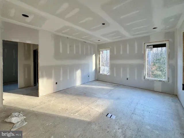 a spacious bedroom with a bed and a chandelier