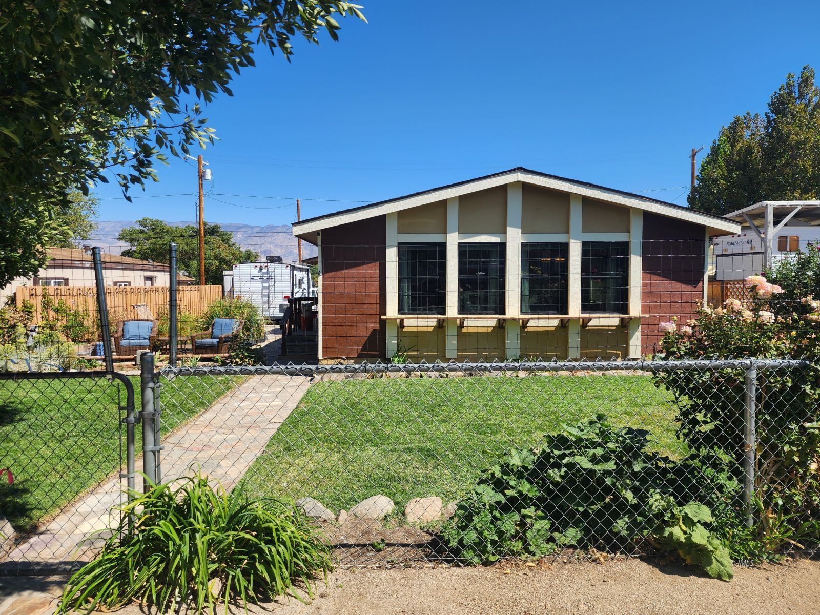 a view of a house with a yard and potted plants