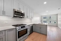 a kitchen with stainless steel appliances granite countertop a sink and a stove top oven with white countertops