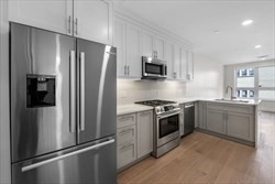 301 Border Street, Unit 406 Boston, MA 02128 - Photo 4 of 21 a kitchen with stainless steel appliances a refrigerator sink and microwave