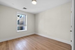 301 Border Street, Unit 406 Boston, MA 02128 - Photo 8 of 21 an empty room with wooden floor and windows