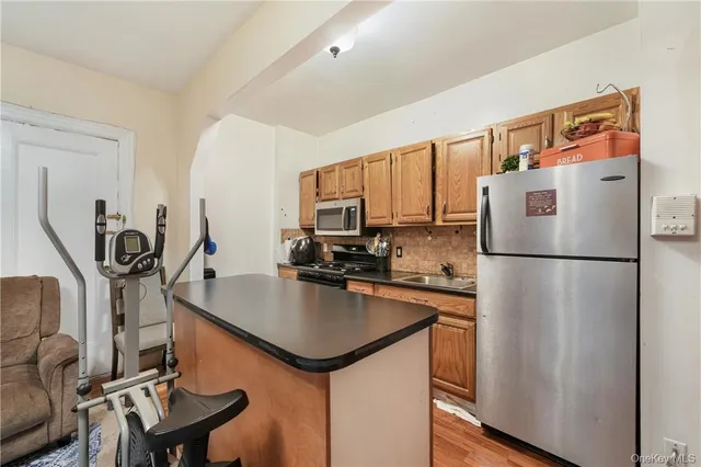 a kitchen with a refrigerator a stove a sink dishwasher and a refrigerator with wooden floor