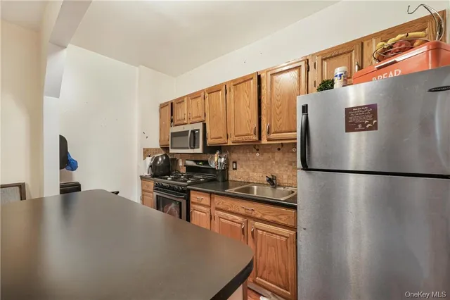 a kitchen with stainless steel appliances a refrigerator stove microwave and sink