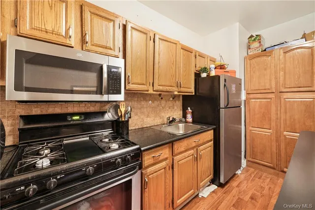 a kitchen with granite countertop a refrigerator stove and microwave