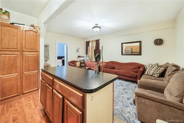 a living room with stainless steel appliances granite countertop furniture and a refrigerator