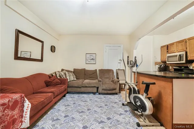 a living room with furniture a flat screen tv and a window