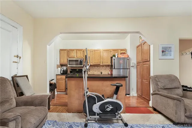a living room with furniture and a gym machine