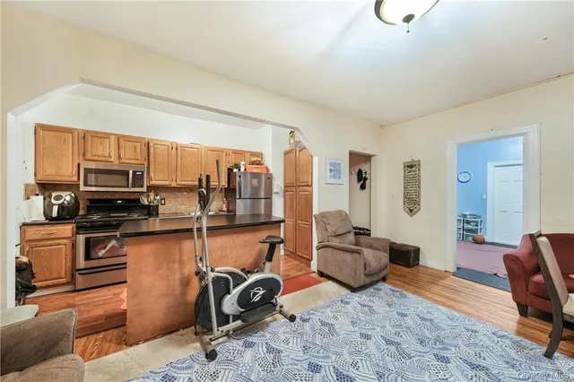 a living room with furniture a flat screen tv and kitchen view