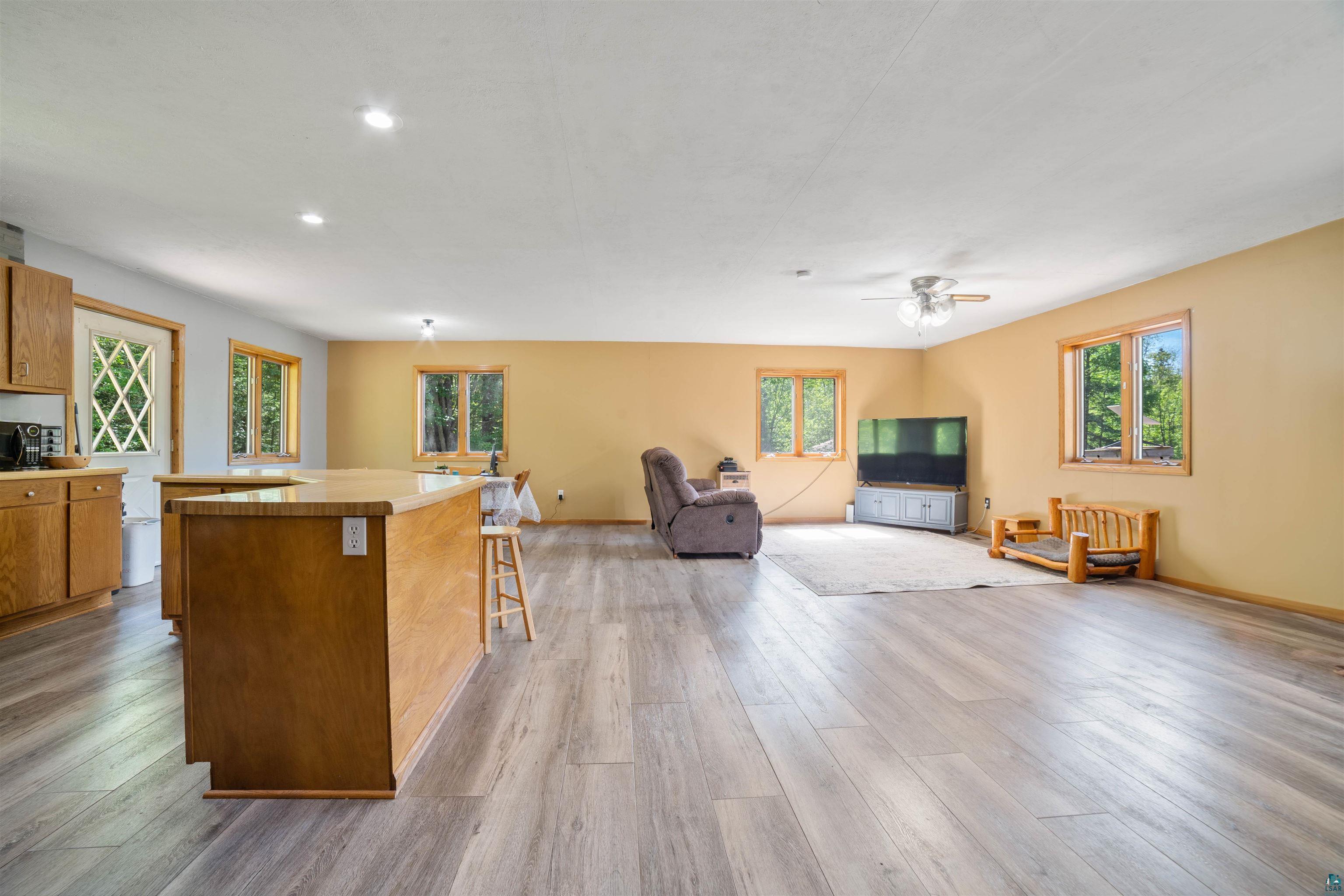 9076 East Moonshine Road South Range, WI 54874 - Photo 12 of 26 Kitchen with hardwood / wood-style floors, a center island, a breakfast bar, and plenty of natural light