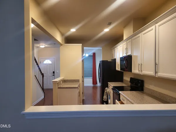 a kitchen with a refrigerator and a stove top oven