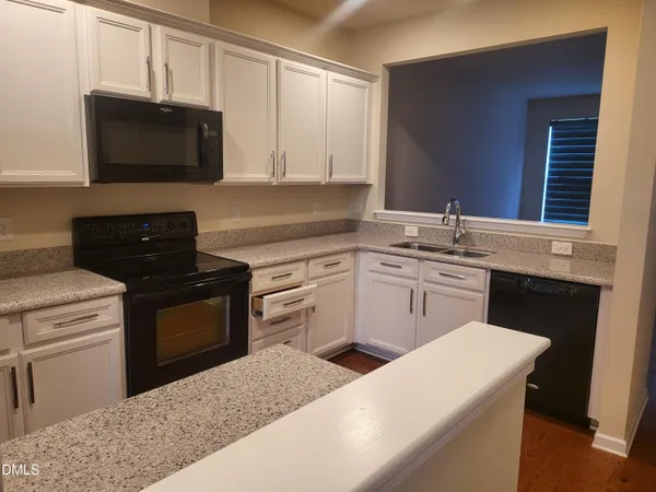 a kitchen with a sink stove and microwave
