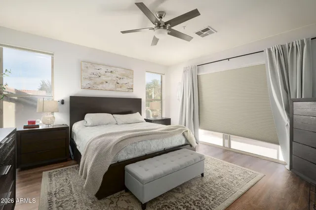 a bedroom with a large bed rug and wooden floor