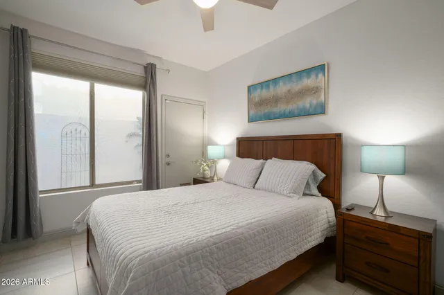 a bedroom with a bed and a lamp on dresser