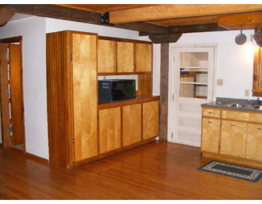 1453 W Road Ashfield, MA 01330 - Photo 10 of 12 a view of a kitchen with an empty room and wooden floor