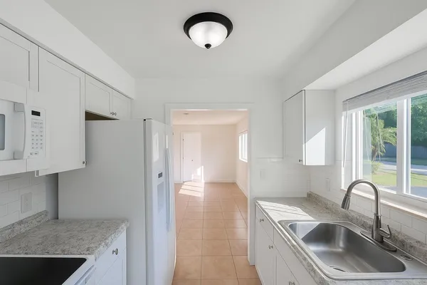 a kitchen with stainless steel appliances granite countertop a sink a stove and a refrigerator