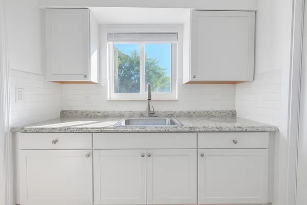 a kitchen with granite countertop cabinets and window