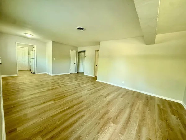 a view of a big room with wooden floor and brick walls