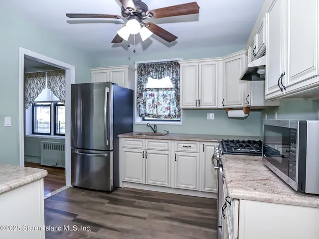 a kitchen with stainless steel appliances granite countertop a refrigerator a stove a sink and a microwave