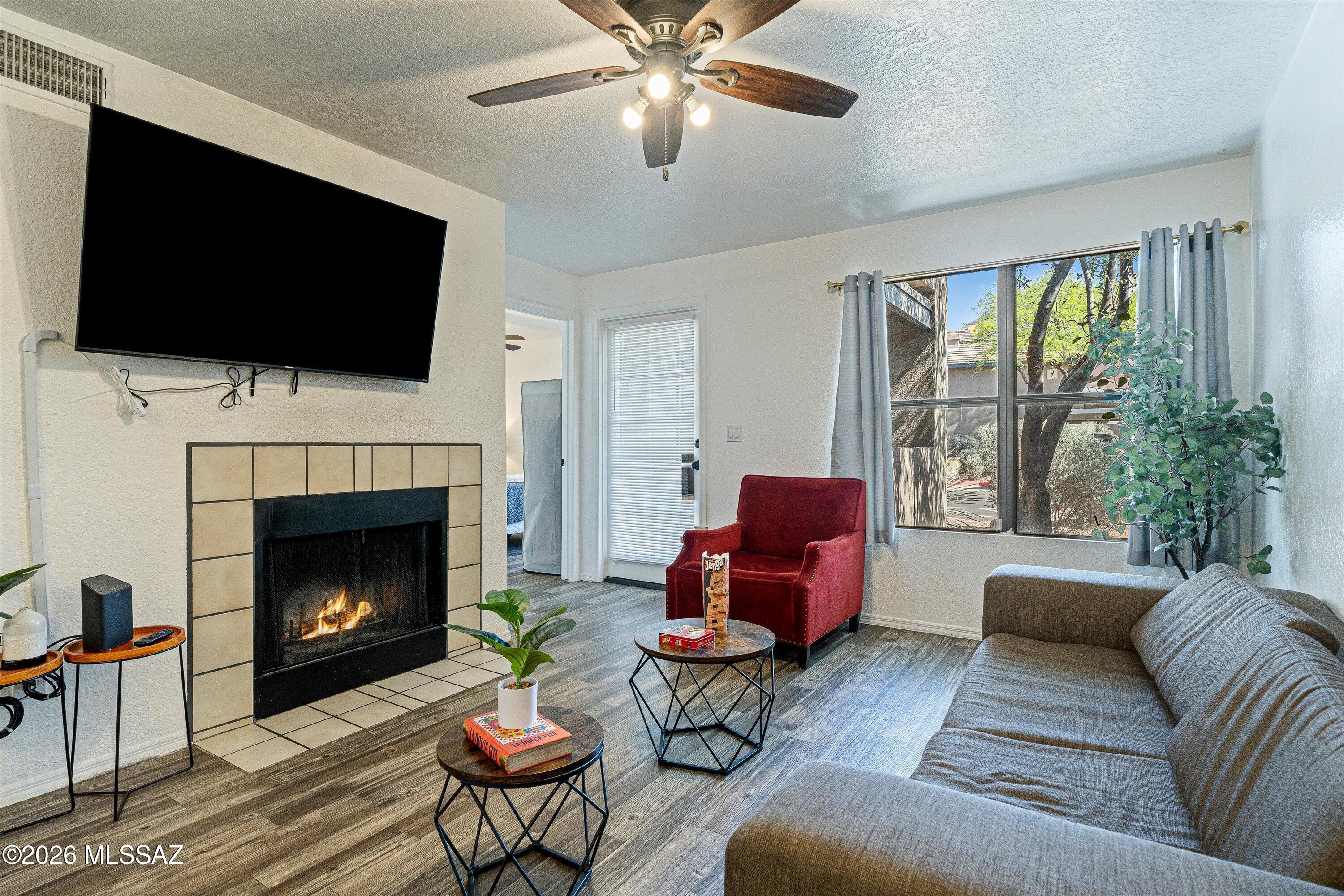 5800 North Kolb Road, Unit 1102 Tucson, AZ 85750 - Photo 4 of 36 a living room with furniture fireplace and a flat screen tv