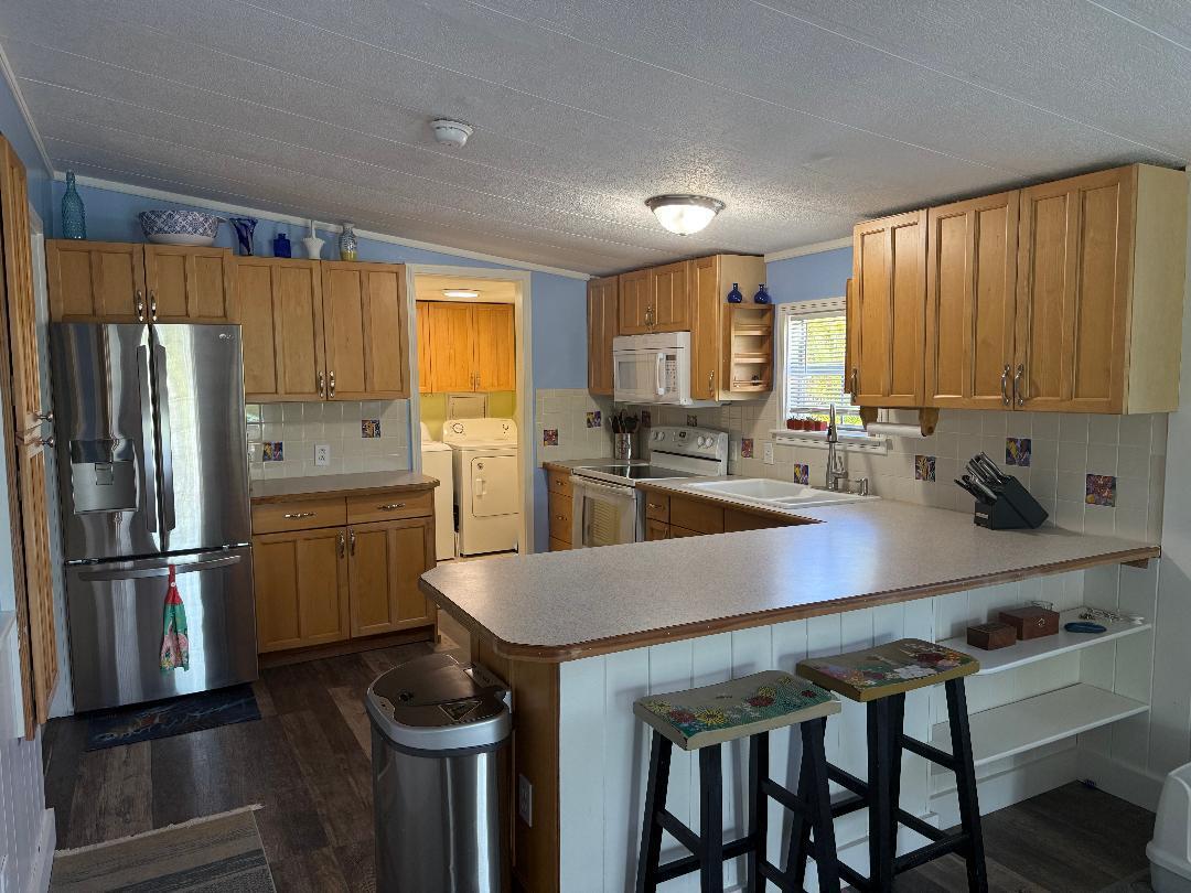 27973 Snapper Lane Summerland Key, FL 33042 - Photo 12 of 25 a kitchen with a table chairs refrigerator and cabinets