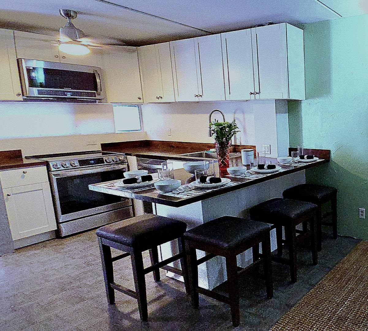 3676 Lower Honoapiilani Road, Unit F102 Lahaina, HI 96761 - Photo 2 of 12 a kitchen with a stove a microwave and cabinets