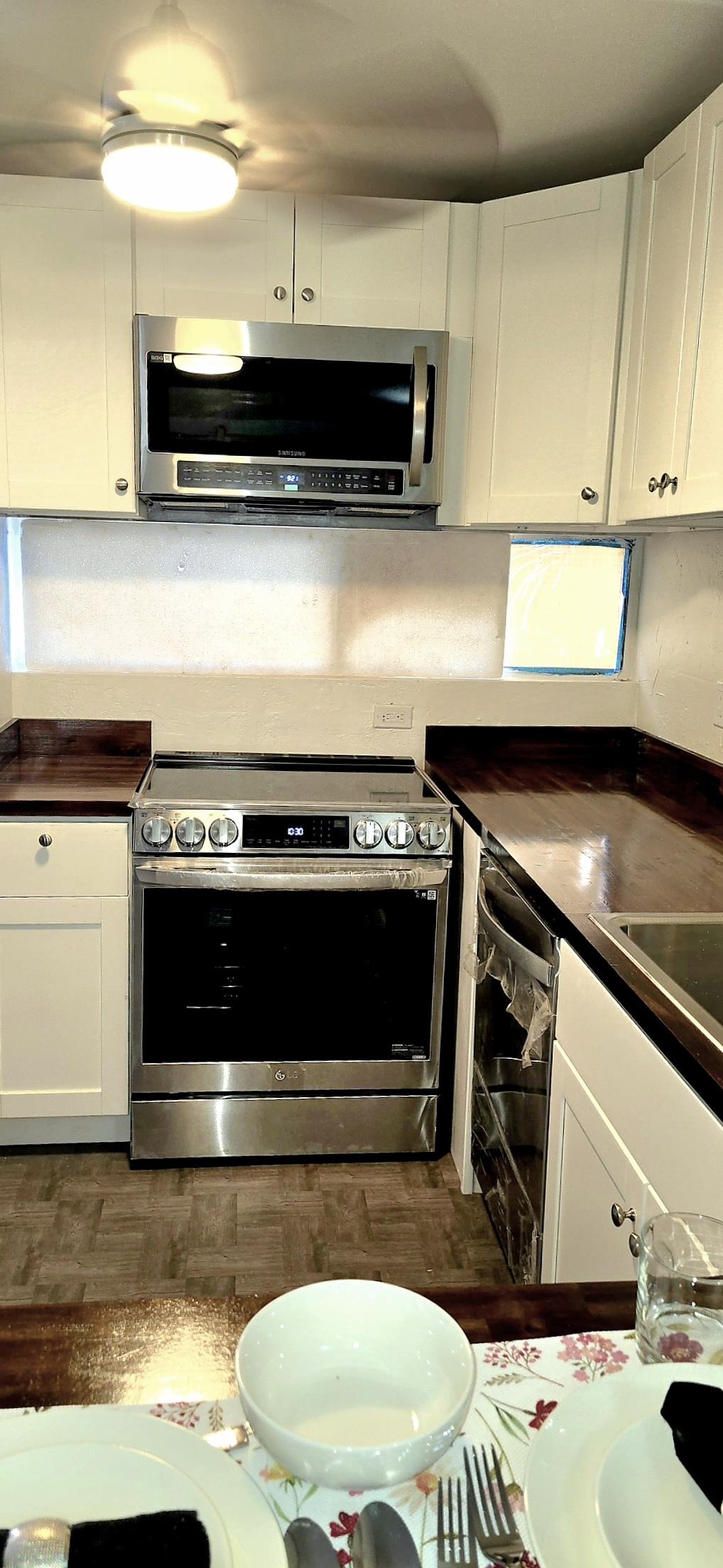 3676 Lower Honoapiilani Road, Unit F102 Lahaina, HI 96761 - Photo 5 of 12 a kitchen with a stove and a microwave