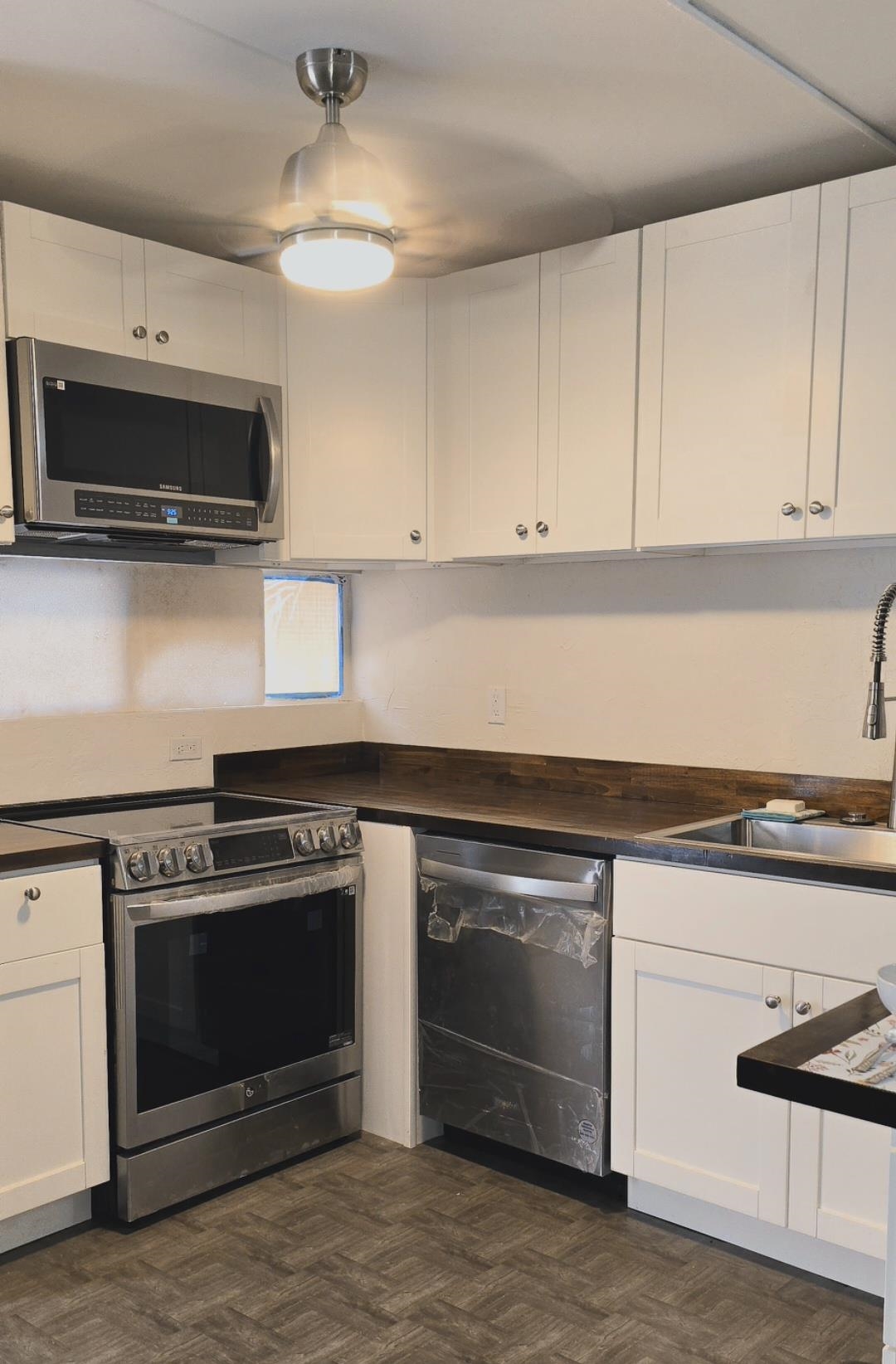 3676 Lower Honoapiilani Road, Unit F102 Lahaina, HI 96761 - Photo 8 of 12 a kitchen with a stove and a microwave