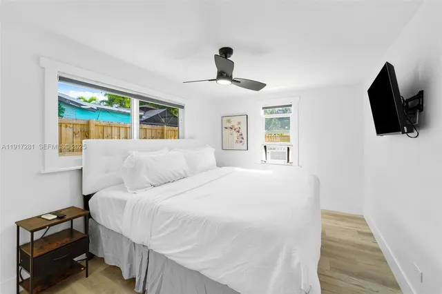 a bedroom with a large bed and a flat tv screen on a dresser