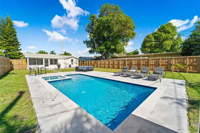 a view of swimming pool with outdoor seating and plants