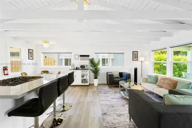 a living room with furniture large window and wooden floor