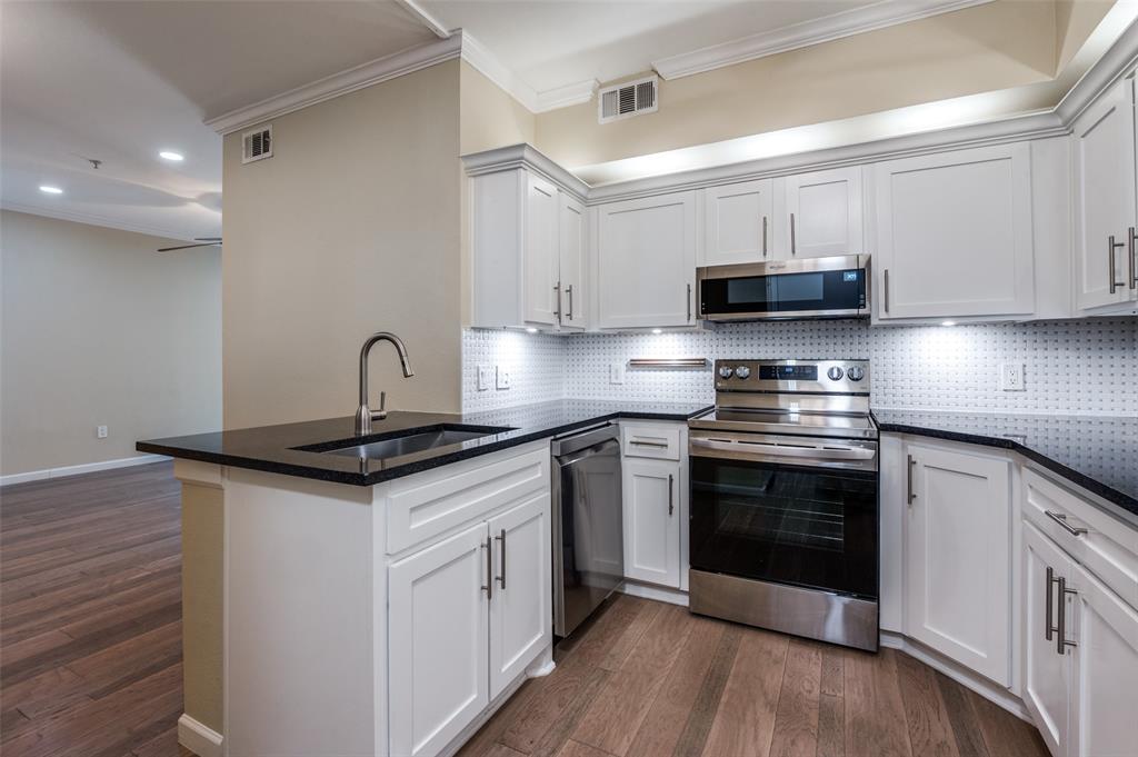 2601 Preston Road, Unit 3103 Plano, TX 75093 - Photo 13 of 30 a kitchen with stainless steel appliances granite countertop a sink stove and microwave