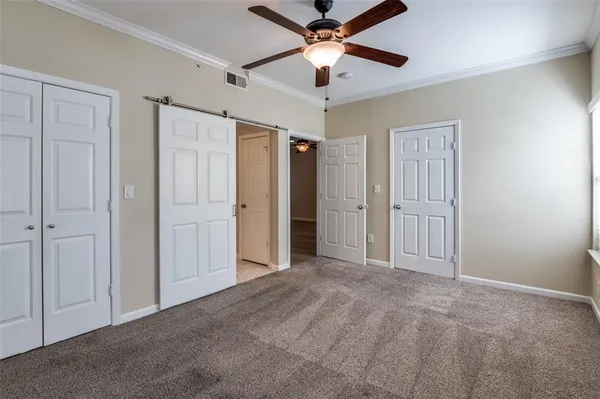 an empty room with closet and a ceiling fan