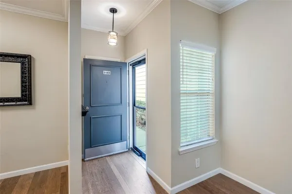 a view of an empty room with window and wooden floor