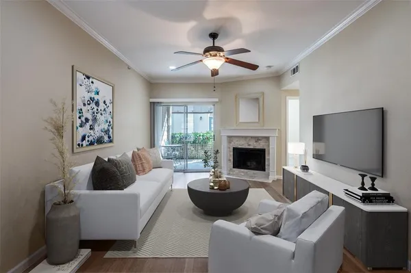 a view of an empty room with wooden floor fireplace and a window