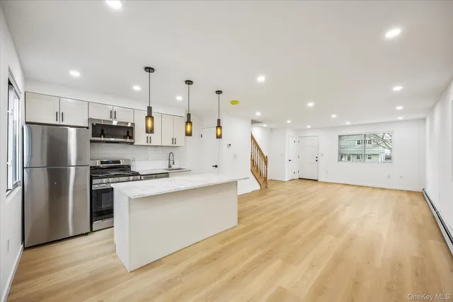 a large kitchen with stainless steel appliances kitchen island a large counter top and a stove top oven