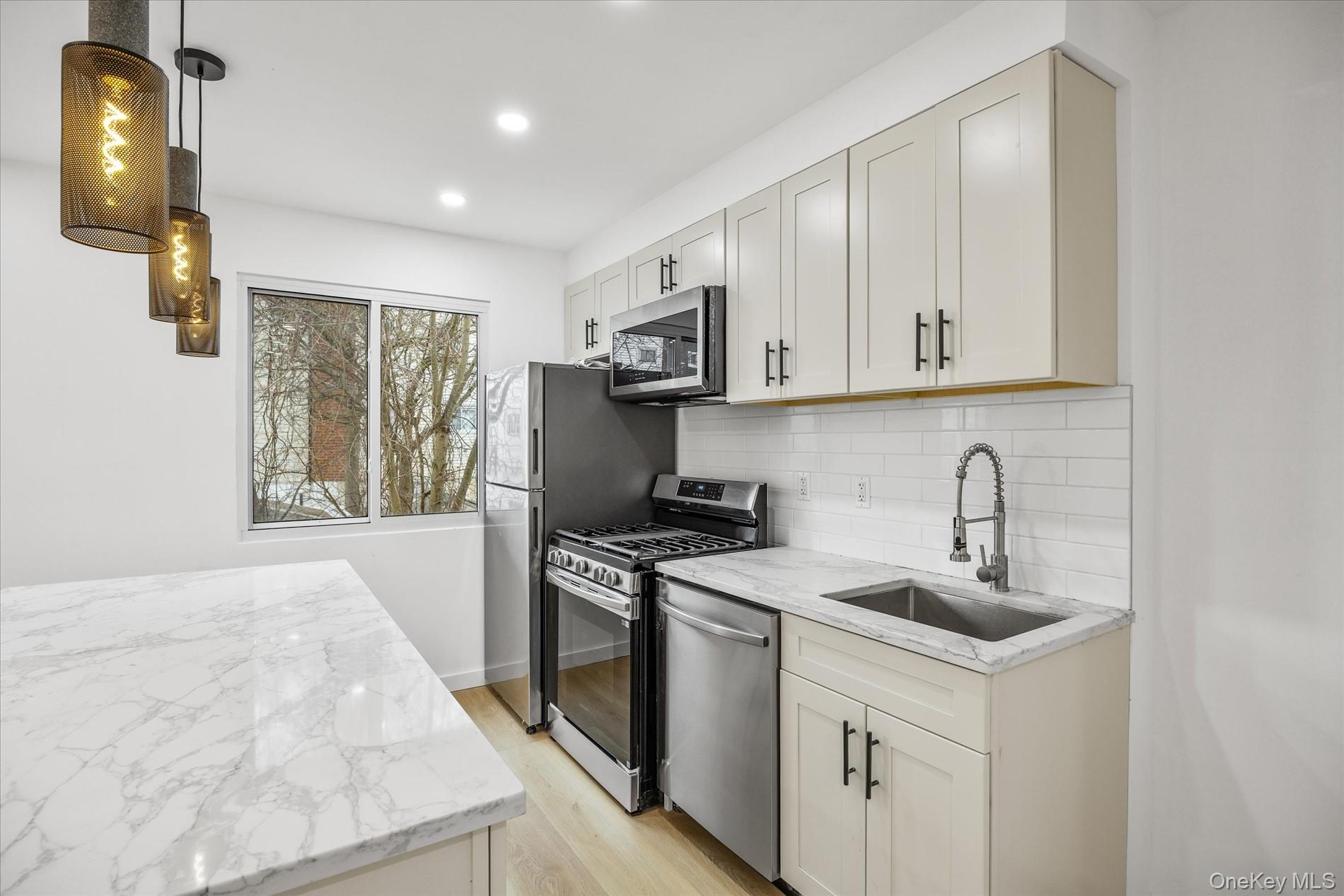 641 Beach 65th Street Queens, NY 11692 - Photo 13 of 34 a kitchen with stainless steel appliances granite countertop a sink stove and cabinets