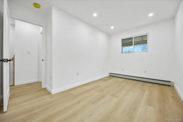 a view of a room with wooden floor and white walls