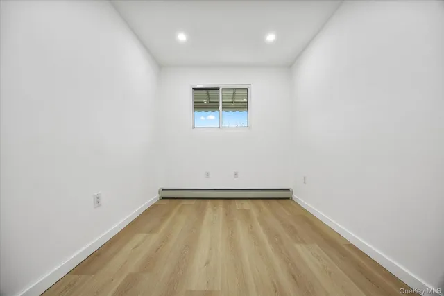 a view of a room with wooden floor and a window