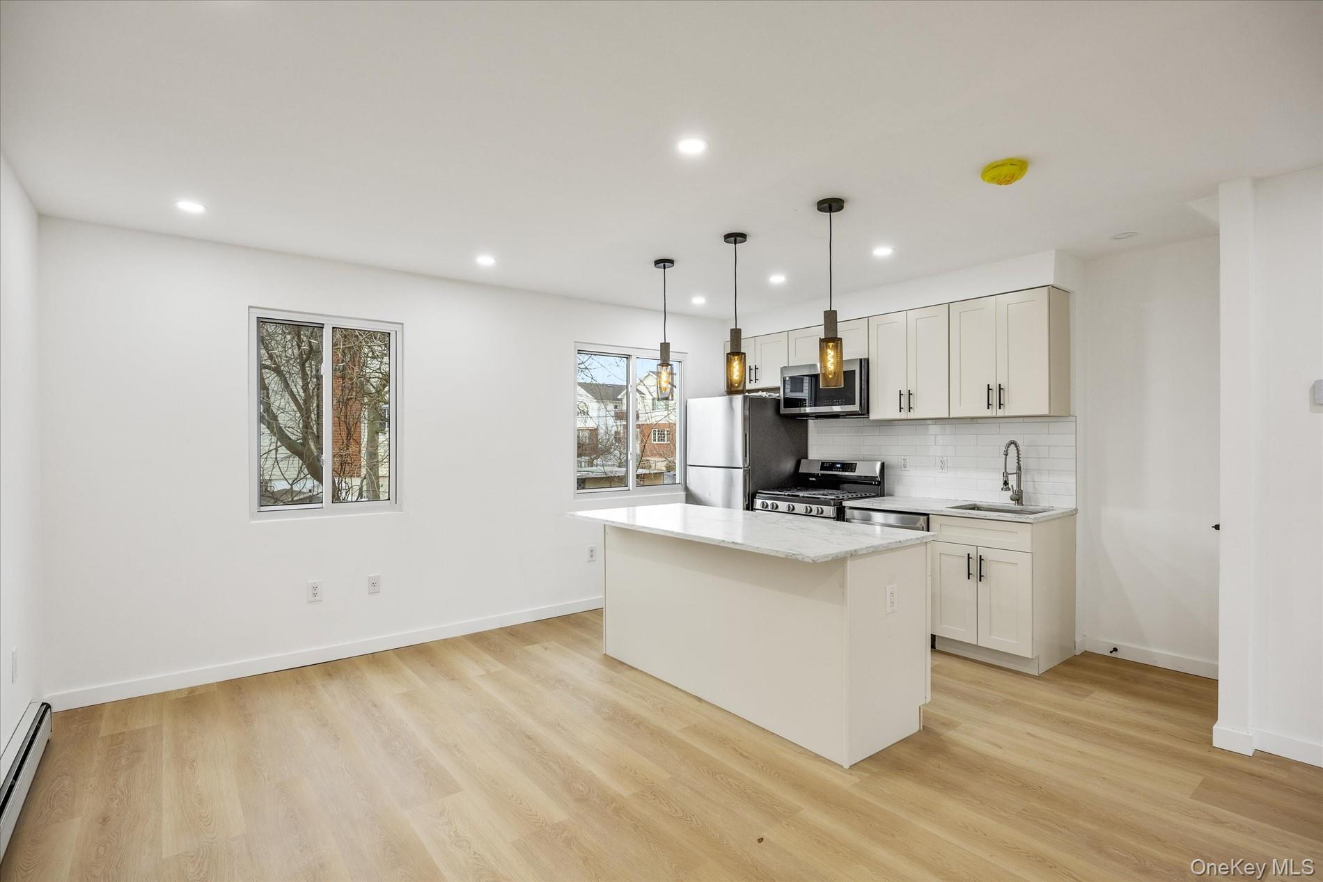 641 Beach 65th Street Queens, NY 11692 - Photo 9 of 34 a kitchen with stainless steel appliances granite countertop a stove a sink and a refrigerator