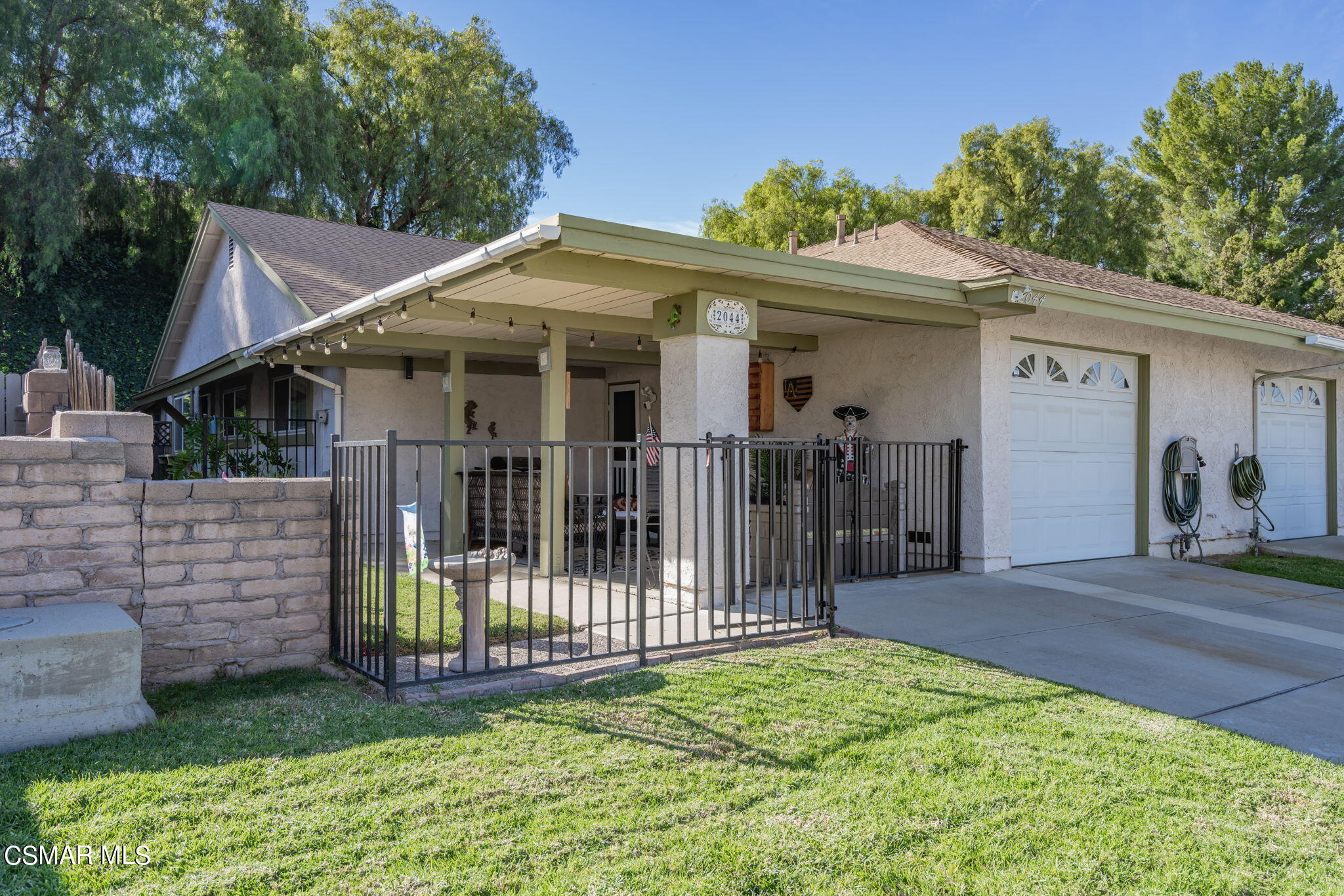 a view of a small house with wooden fence