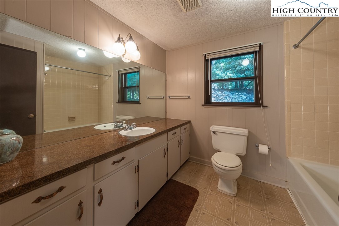 377 Deer Run Road Glade Valley, NC 28627 - Photo 21 of 26 a bathroom with a toilet sink and mirror